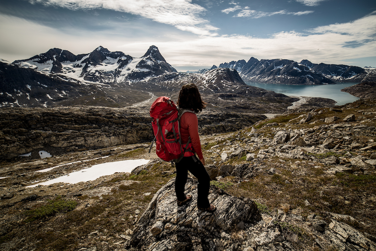 A Hiker Looking Towards Tasiilaq Island In East Greenland